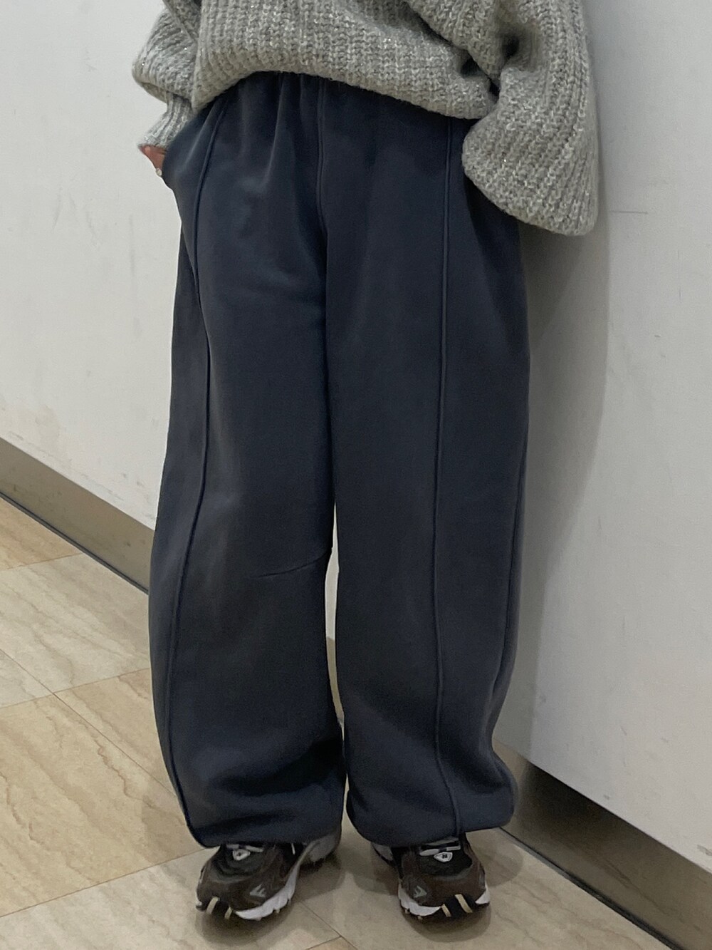 グレー系のニット/セーター、グレー系のスウェットパンツを着用したレディースの冬コーディネートの5枚目の写真