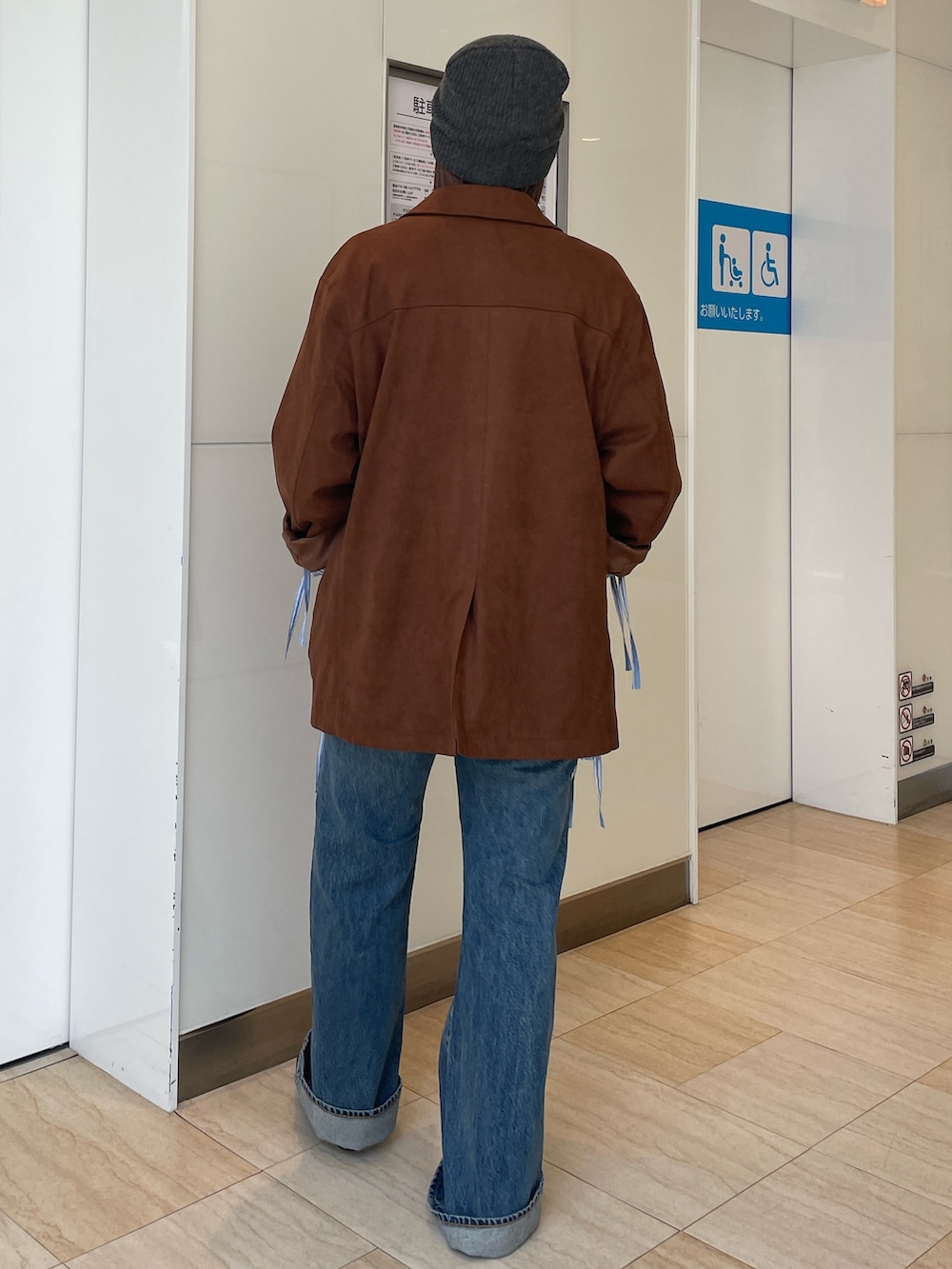 ブラウン系のテーラードジャケット、ブルー系のシャツ/ブラウス、ブルー系のデニムパンツを着用したレディースの春コーディネートの3枚目の写真