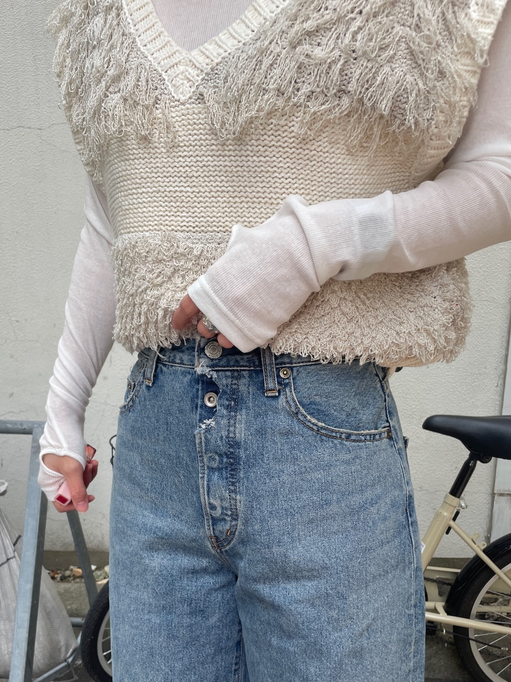 ブルー系のデニムパンツ、ホワイト系のベスト、ホワイト系のTシャツ/カットソーを着用したレディースの冬コーディネートの5枚目の写真