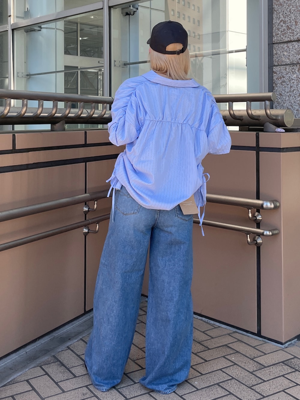 ブルー系のデニムパンツ、ブルー系のシャツ/ブラウス、ブラック系のキャミソールを着用したレディースの夏コーディネートの3枚目の写真