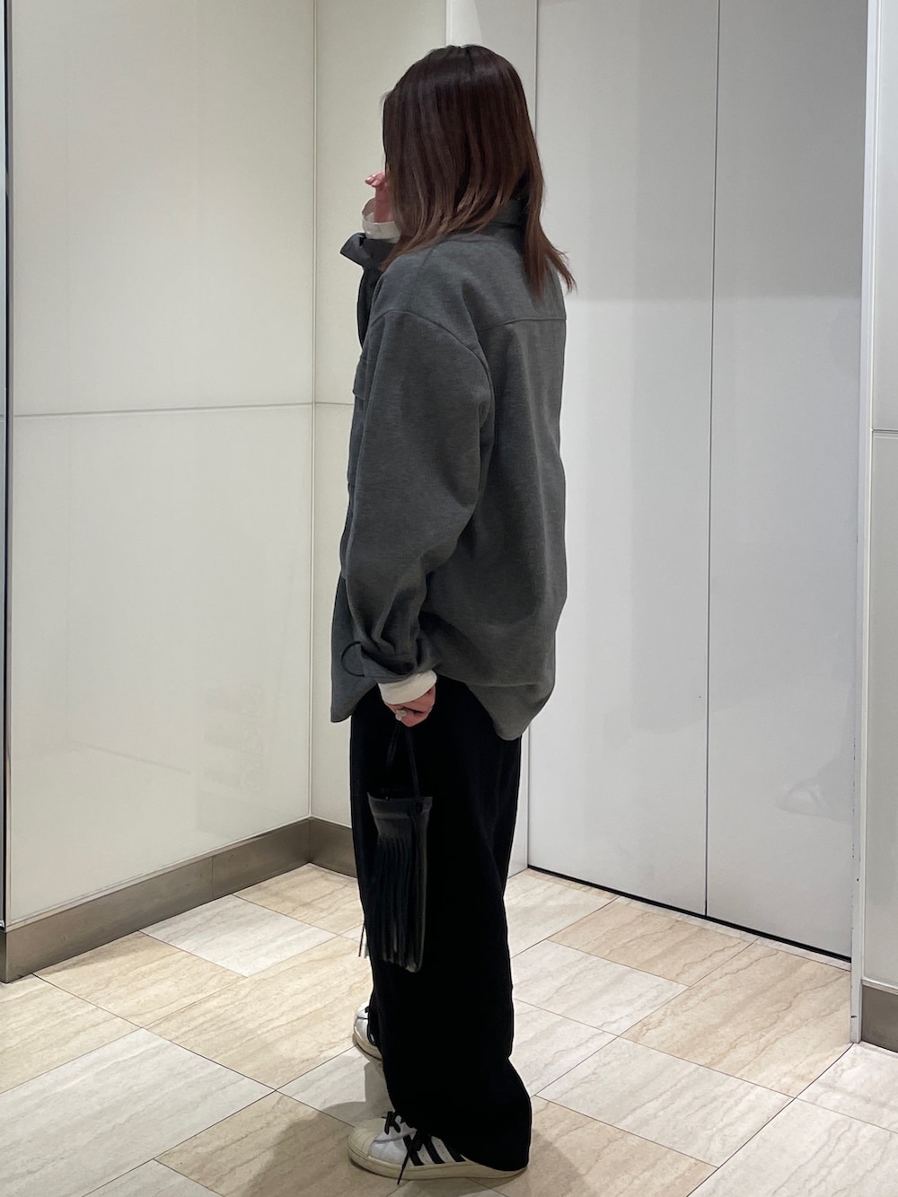グレー系のシャツ/ブラウス、ブラック系のその他パンツ、ホワイト系のTシャツ/カットソーを着用したレディースの秋コーディネートの2枚目の写真