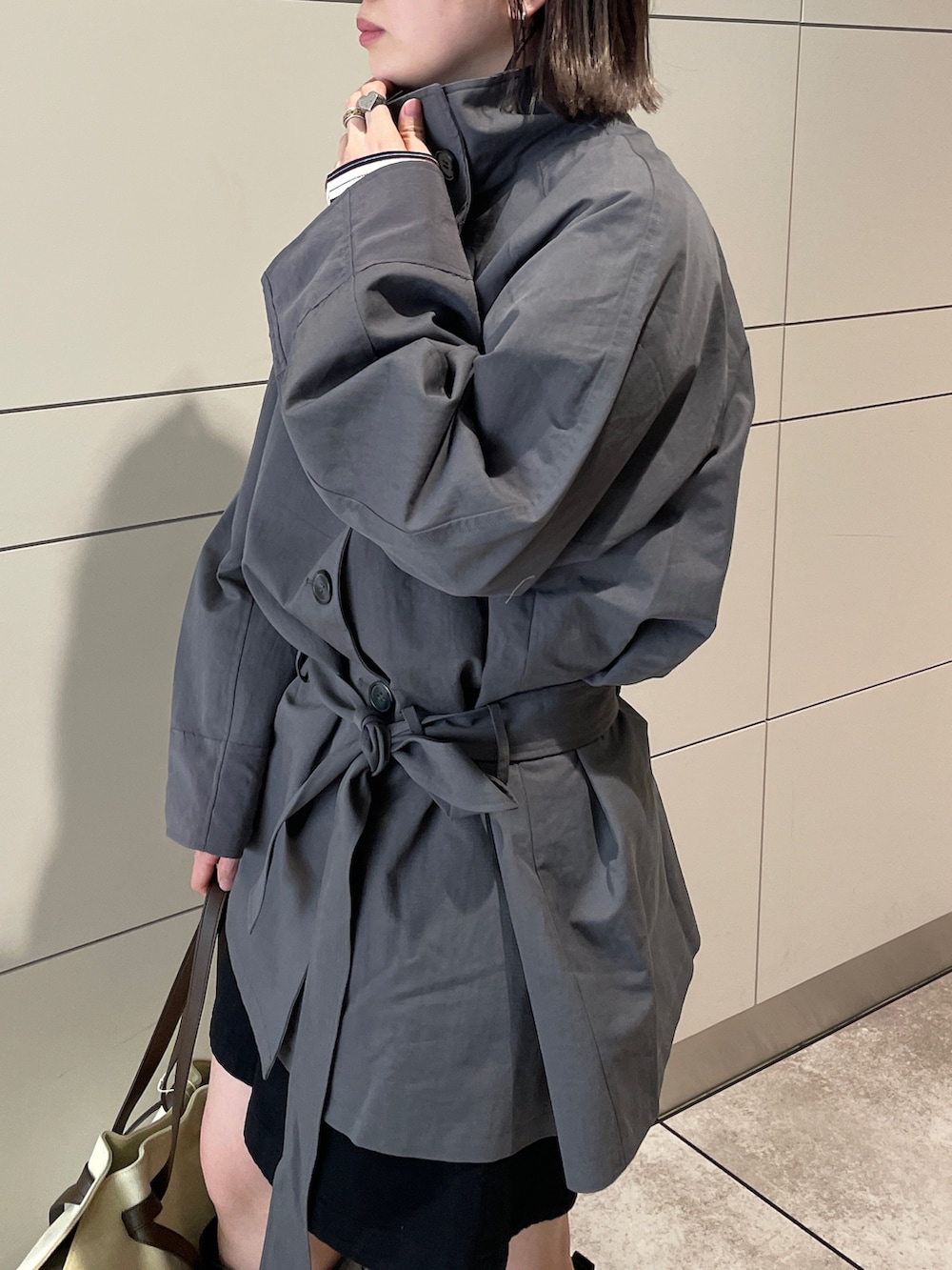 グレー系のトレンチコート、ブラック系のその他パンツ、ブラウン系のトートバッグを着用したレディースの冬コーディネートの5枚目の写真