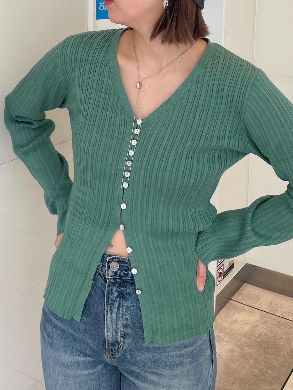 グリーン系のカーディガン/ボレロ、ブルー系のデニムパンツ、グレー系のニットキャップ/ビーニーを着用したレディースの春コーディネートの4枚目の写真