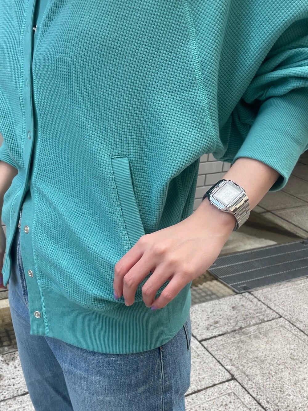 ブルー系のカーディガン/ボレロ、ブルー系のデニムパンツ、ホワイト系のキャップを着用したレディースの冬コーディネートの7枚目の写真