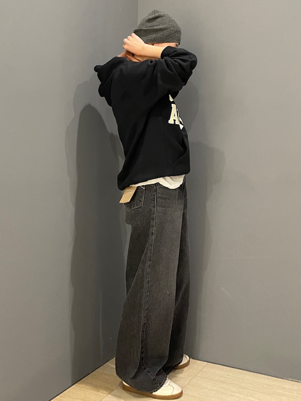 ブラック系のパーカー、ホワイト系のTシャツ/カットソー、ブラック系のデニムパンツを着用したレディースの秋コーディネートの2枚目の写真