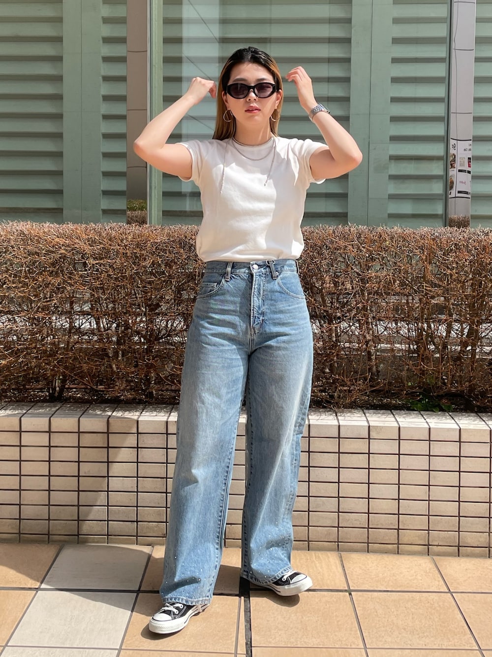 ブルー系のデニムパンツ、ホワイト系のTシャツ/カットソー、シルバー系のネックレスを着用したレディースの春コーディネートの2枚目の写真