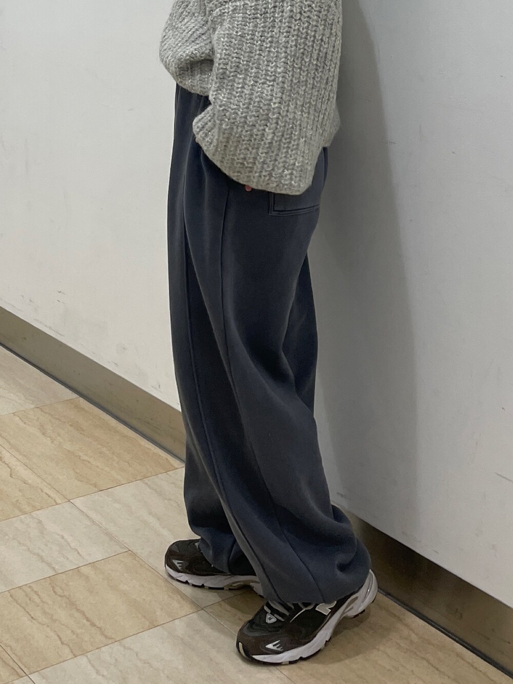 グレー系のニット/セーター、グレー系のスウェットパンツを着用したレディースの冬コーディネートの6枚目の写真