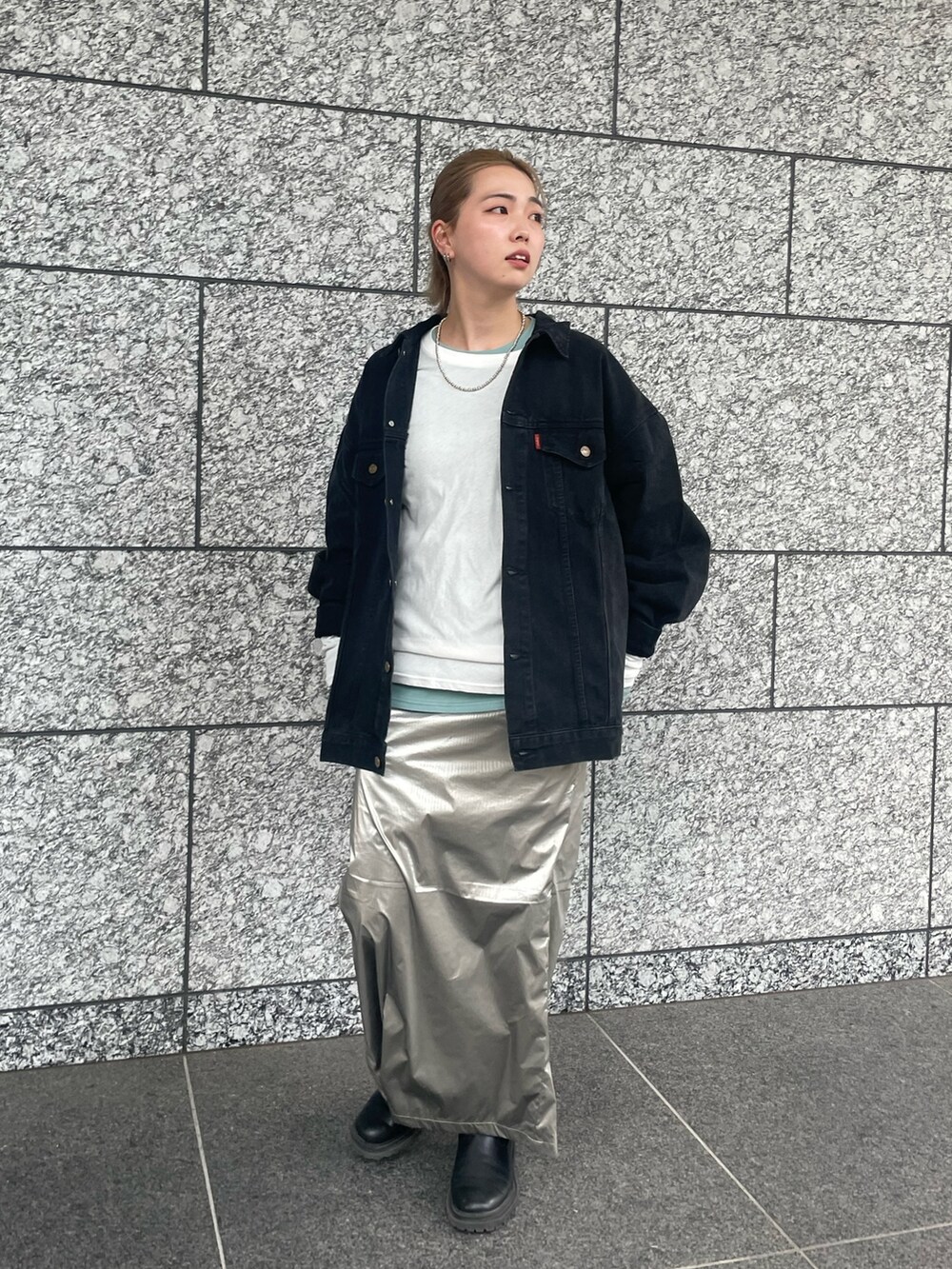 シルバー系のスカート、ブルー系のTシャツ/カットソー、ブラック系のデニムジャケットを着用したレディースの夏コーディネートの4枚目の写真