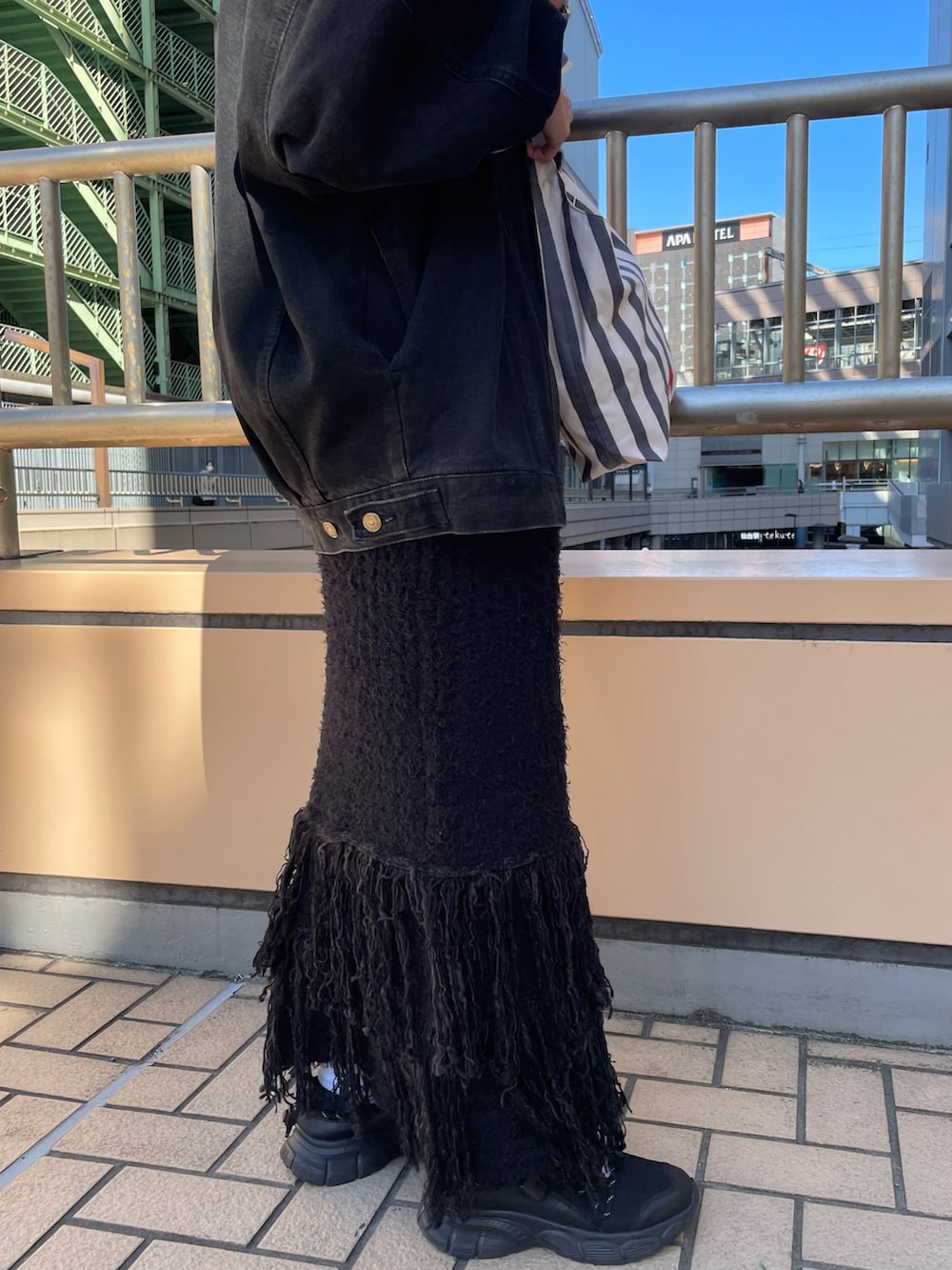 ブラック系のデニムジャケット、ホワイト系のTシャツ/カットソー、ブラック系のスカートを着用したレディースの秋コーディネートの6枚目の写真