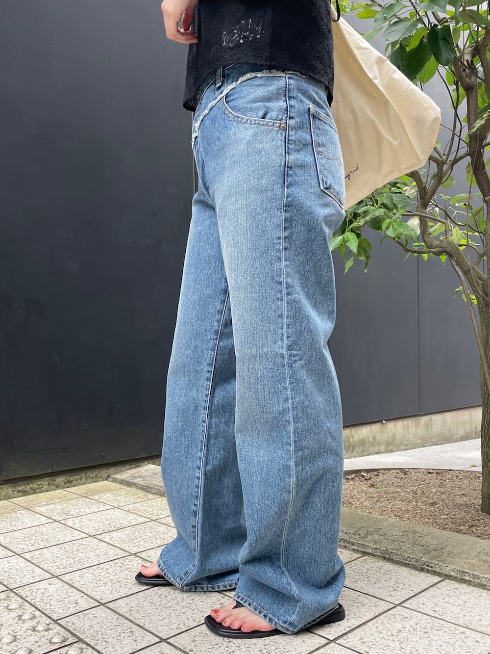 ブルー系のデニムパンツ、ブラック系のタンクトップ、ブラック系のキャミソールを着用したレディースの夏コーディネートの5枚目の写真