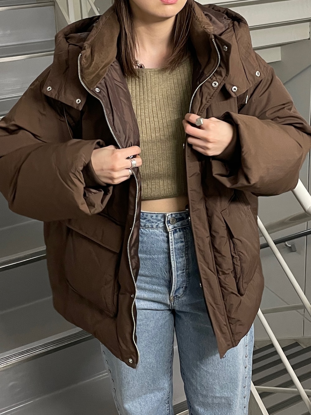 ブルー系のデニムパンツ、ブラック系のブーツ、ブラウン系のダウンジャケット/コートを着用したレディースの秋コーディネートの4枚目の写真