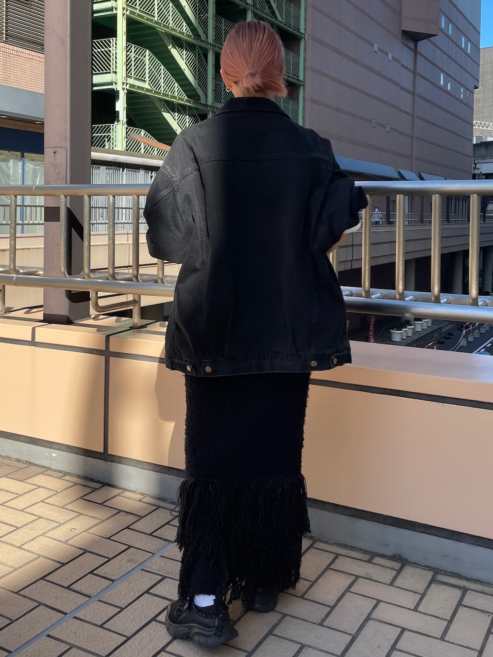 ブラック系のデニムジャケット、ホワイト系のTシャツ/カットソー、ブラック系のスカートを着用したレディースの秋コーディネートの3枚目の写真