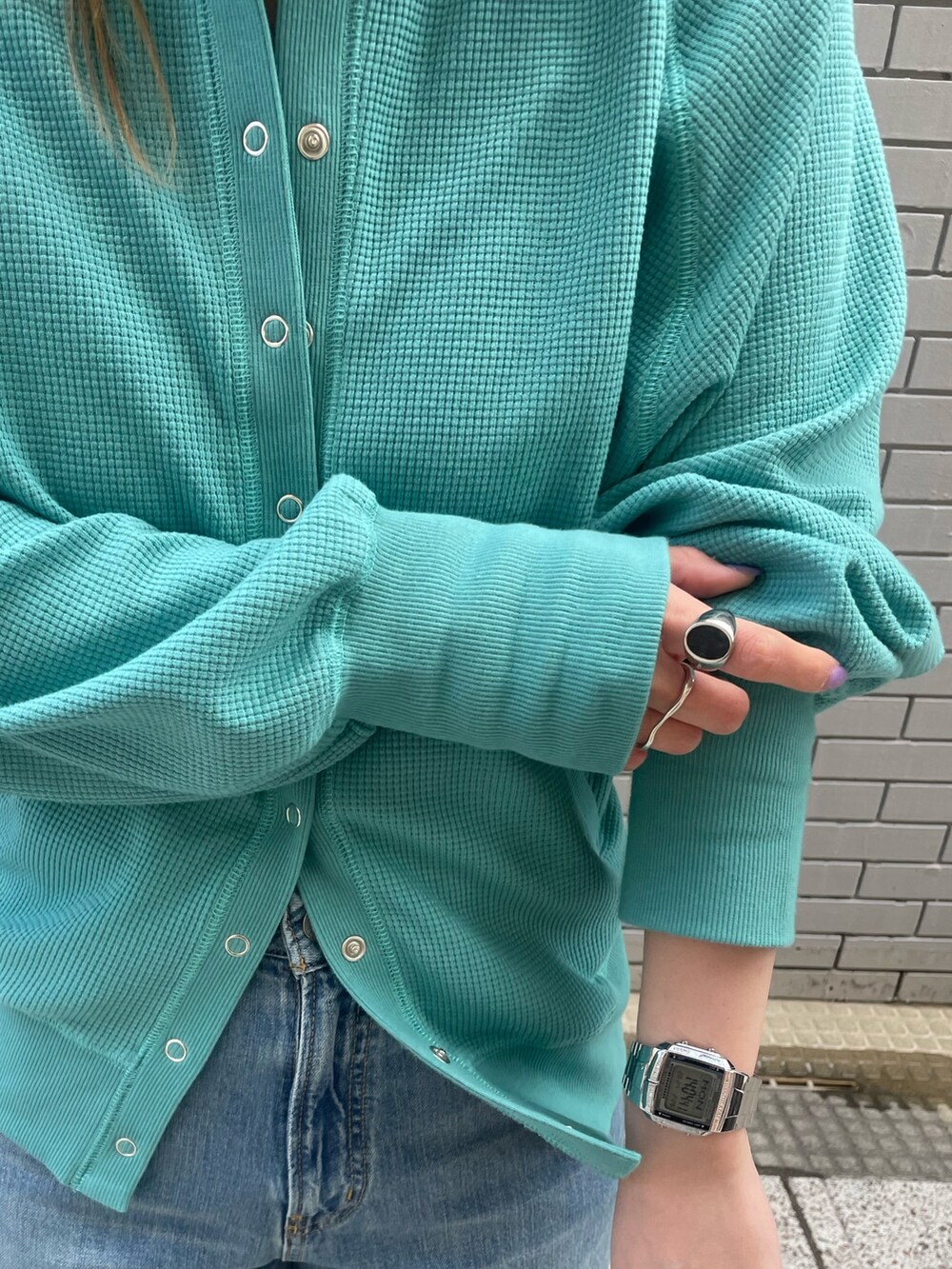 ブルー系のカーディガン/ボレロ、ブルー系のデニムパンツ、ホワイト系のキャップを着用したレディースの冬コーディネートの5枚目の写真