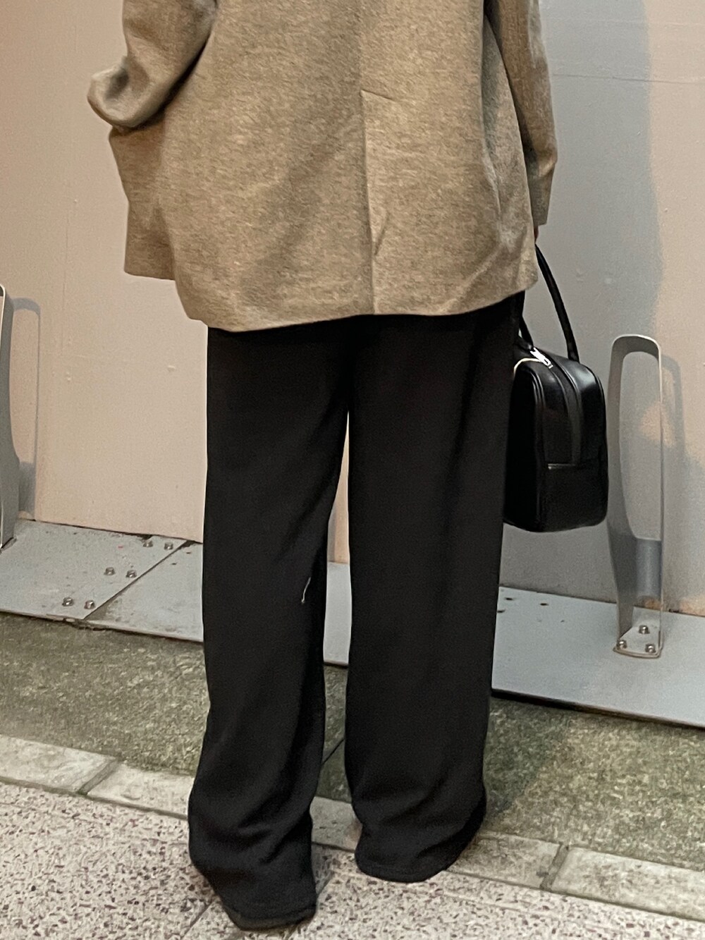 グレー系のテーラードジャケット、グレー系のスウェットパンツ、ブラック系のハンドバッグを着用したレディースの秋コーディネートの7枚目の写真