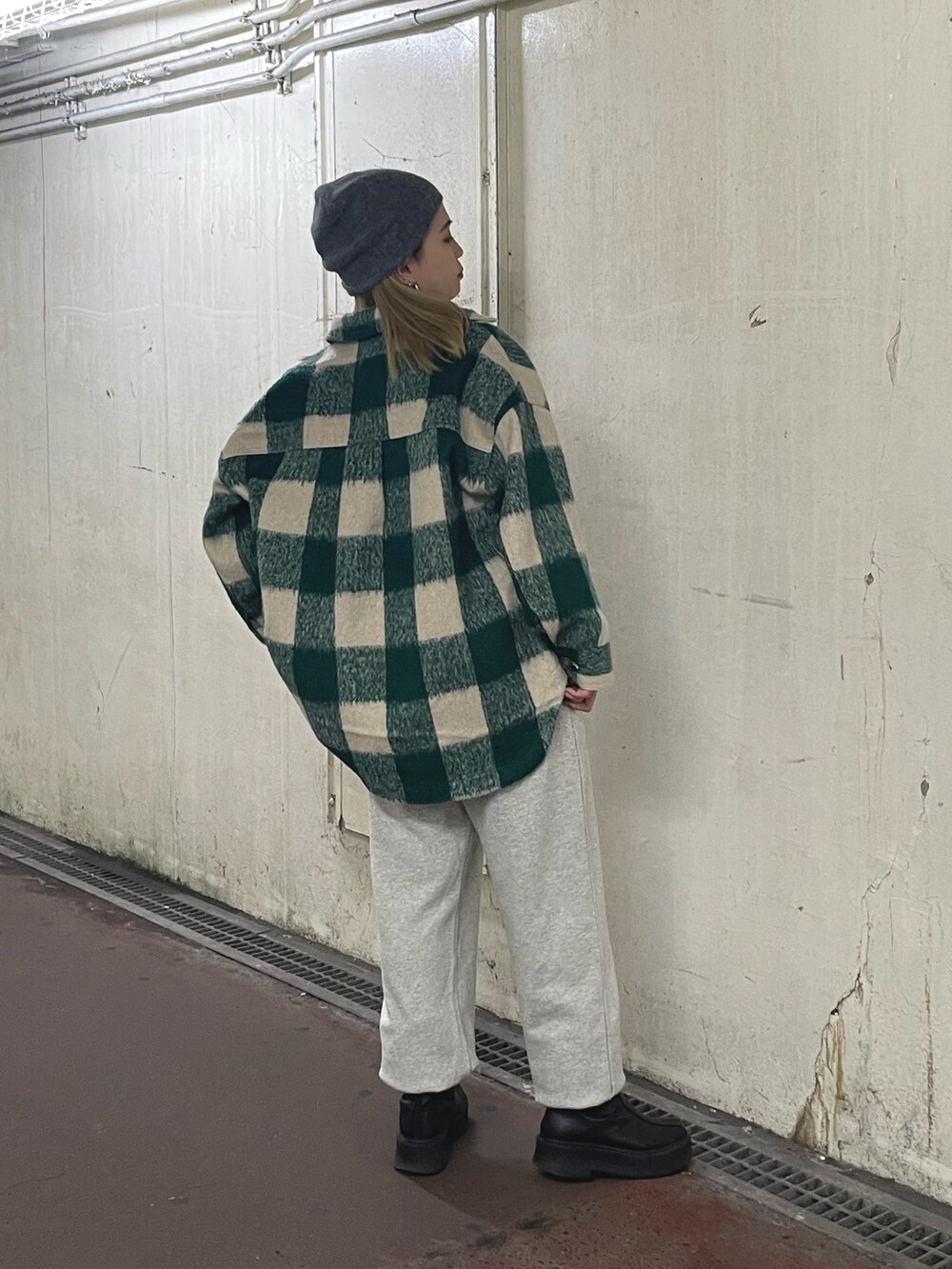 グリーン系のシャツ/ブラウス、ホワイト系のTシャツ/カットソー、ブラック系のブーツを着用したレディースの秋コーディネートの4枚目の写真