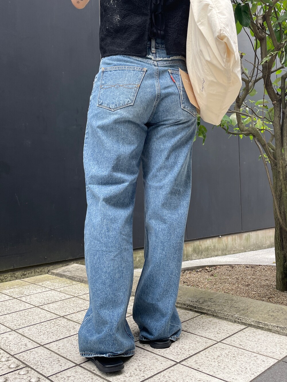 ブルー系のデニムパンツ、ブラック系のタンクトップ、ブラック系のキャミソールを着用したレディースの夏コーディネートの6枚目の写真