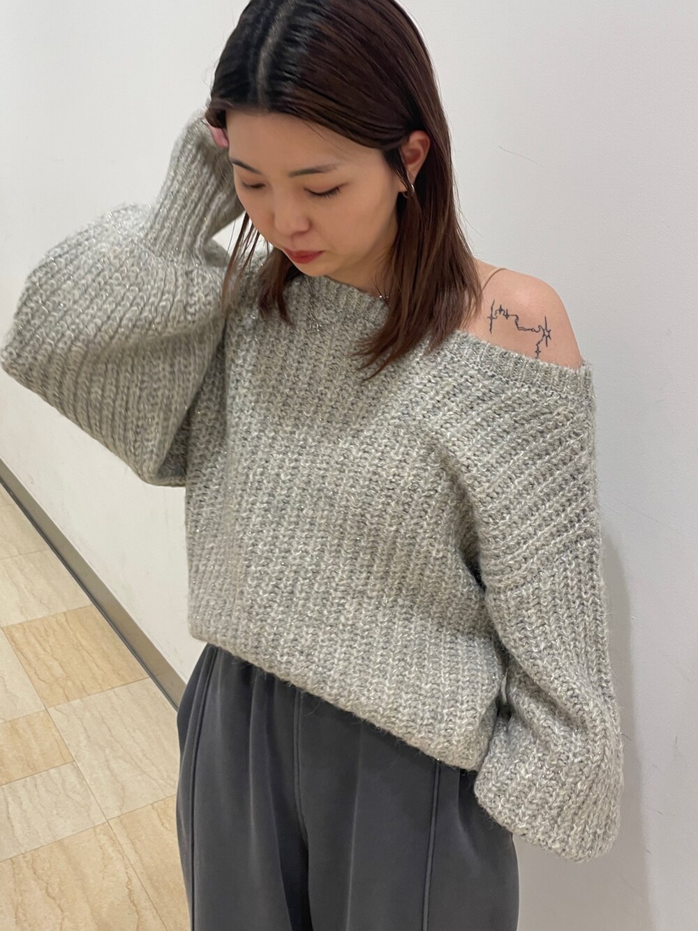 グレー系のニット/セーター、グレー系のスウェットパンツを着用したレディースの冬コーディネートの4枚目の写真