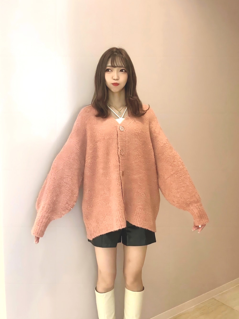 ピンク系のカーディガン/ボレロ、ブラック系のその他パンツ、ホワイト系のブーツを着用したレディースの秋コーディネートの2枚目の写真