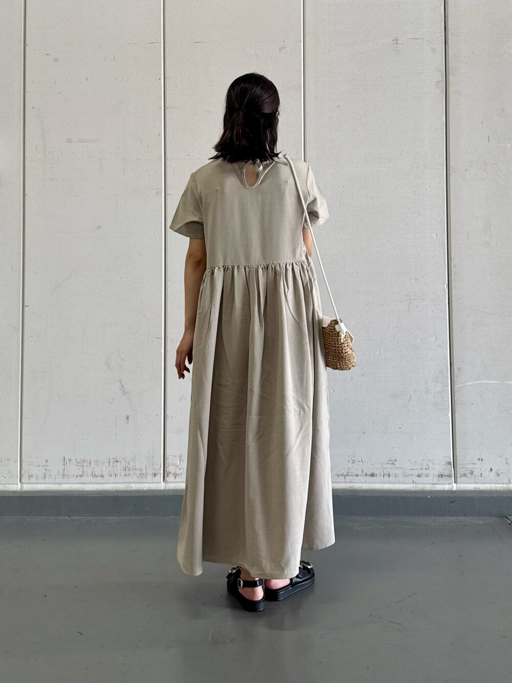 グレー系のワンピース、イエロー系のショルダーバッグ、ブラック系のサンダルを着用したレディースの夏コーディネートの4枚目の写真