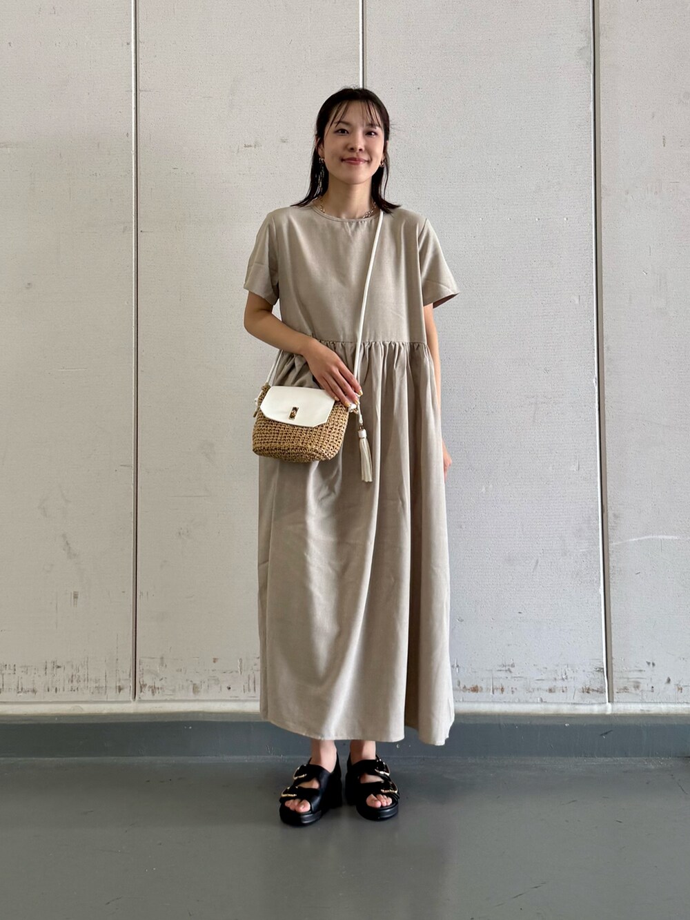 グレー系のワンピース、イエロー系のショルダーバッグ、ブラック系のサンダルを着用したレディースの夏コーディネートの2枚目の写真