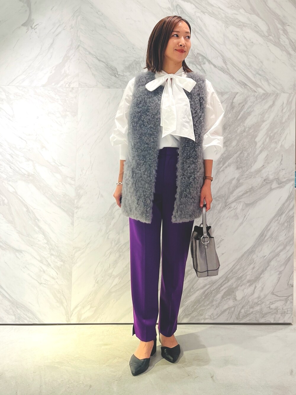 シルバー系のバックパック/リュック、パープル系のスラックス、ホワイト系のシャツ/ブラウスを着用したレディースの秋コーディネートの2枚目の写真