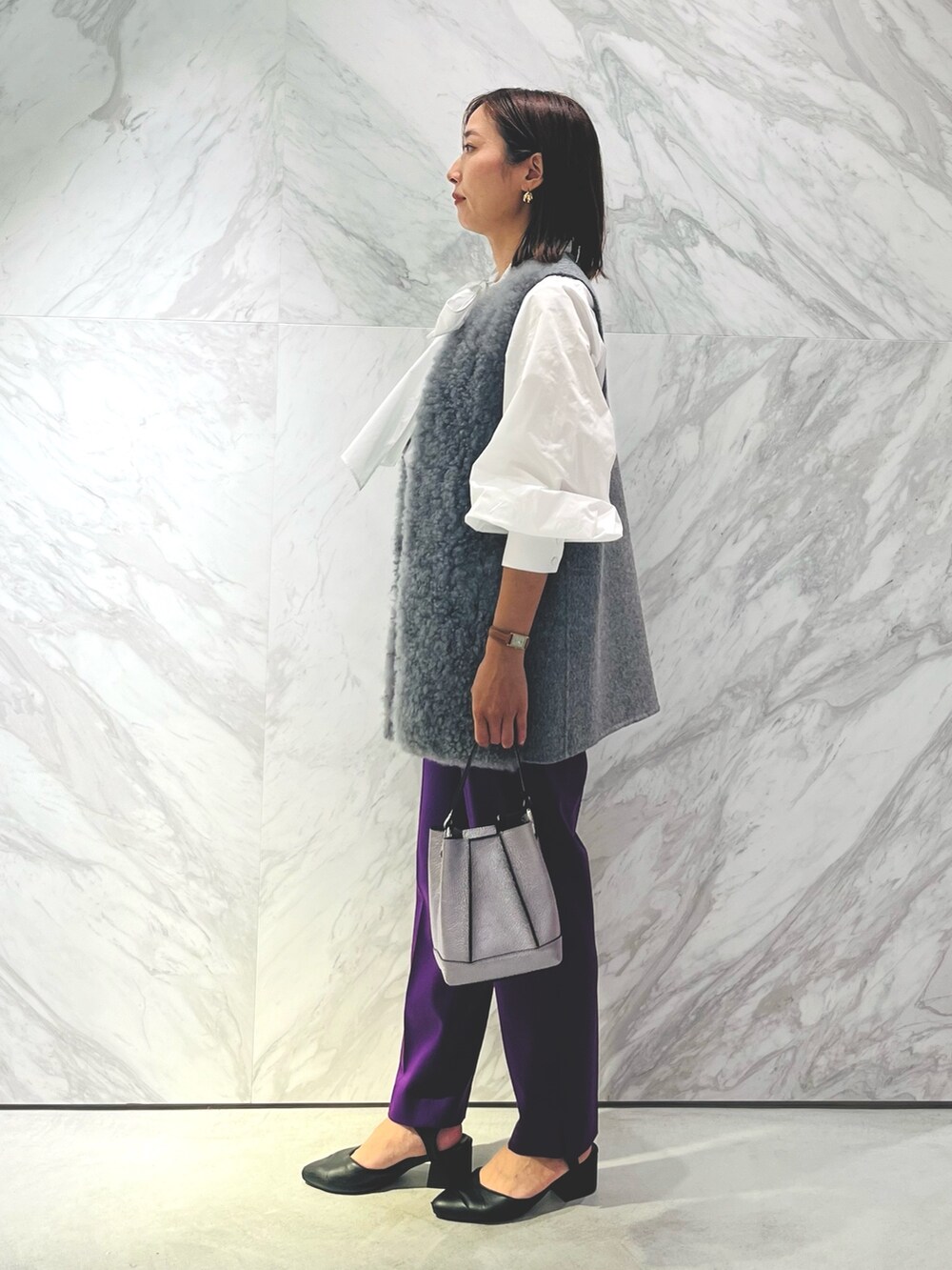 シルバー系のバックパック/リュック、パープル系のスラックス、ホワイト系のシャツ/ブラウスを着用したレディースの秋コーディネートの3枚目の写真