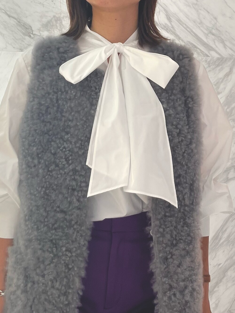 シルバー系のバックパック/リュック、パープル系のスラックス、ホワイト系のシャツ/ブラウスを着用したレディースの秋コーディネートの5枚目の写真