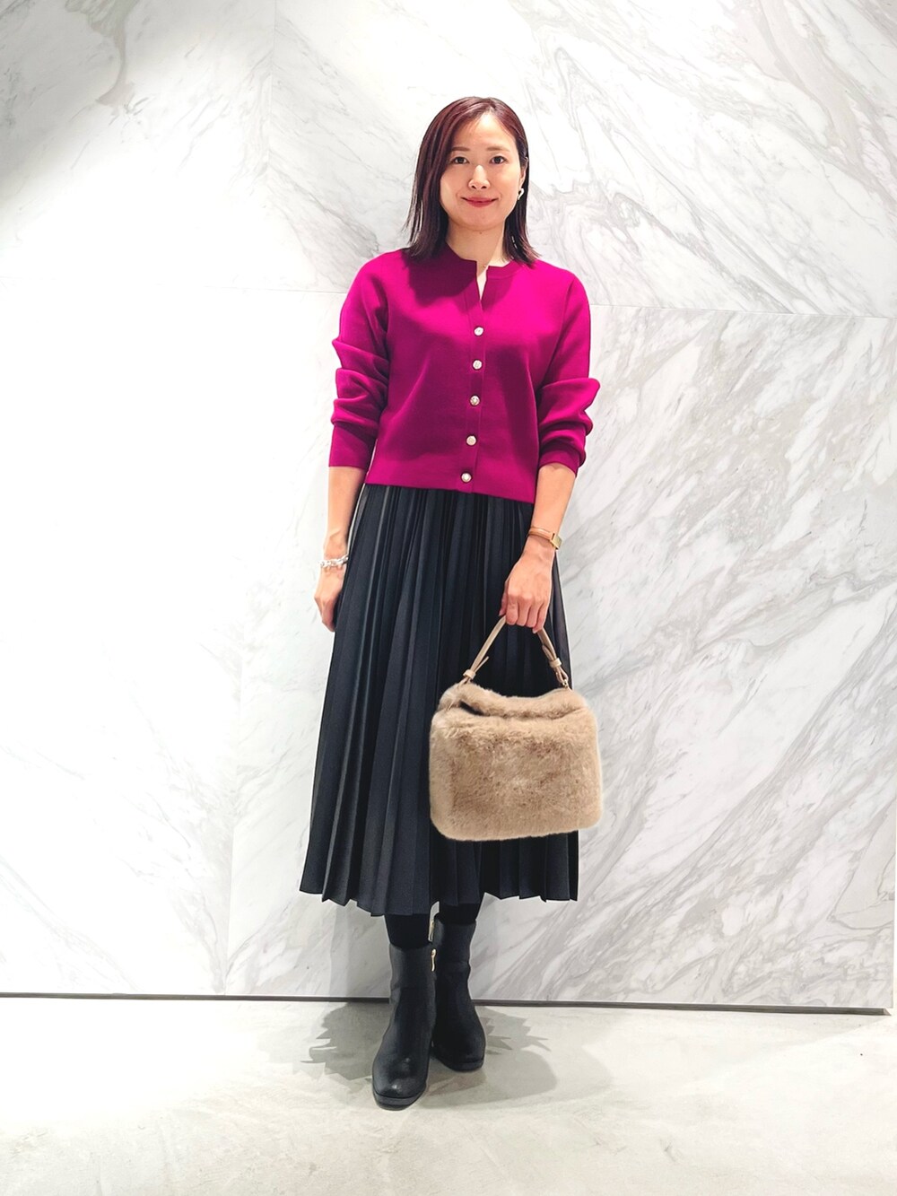 パープル系のカーディガン/ボレロ、グレー系のスカート、ベージュ系のハンドバッグを着用したレディースの秋コーディネートの2枚目の写真