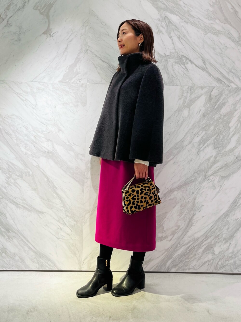 グレー系のその他アウター、ピンク系のスカートを着用したレディースの冬コーディネートの3枚目の写真