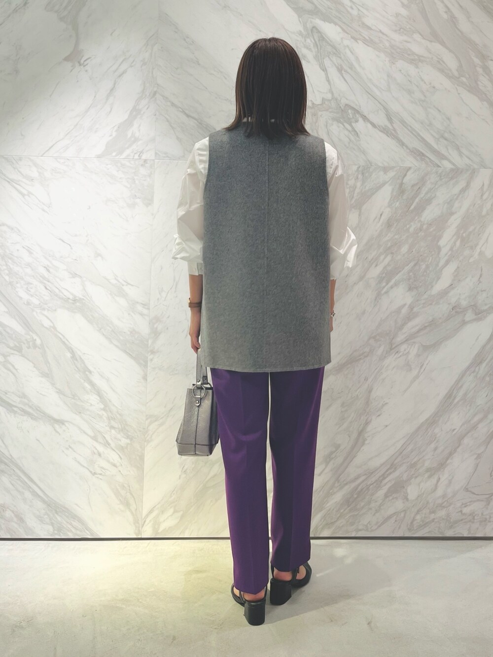 シルバー系のバックパック/リュック、パープル系のスラックス、ホワイト系のシャツ/ブラウスを着用したレディースの秋コーディネートの4枚目の写真