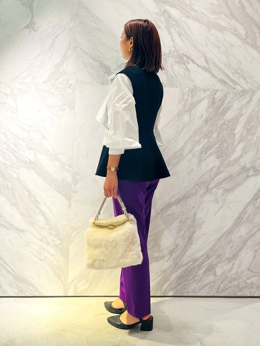 ホワイト系のシャツ/ブラウス、ブラック系のベスト、パープル系のスラックスを着用したレディースの秋コーディネートの3枚目の写真