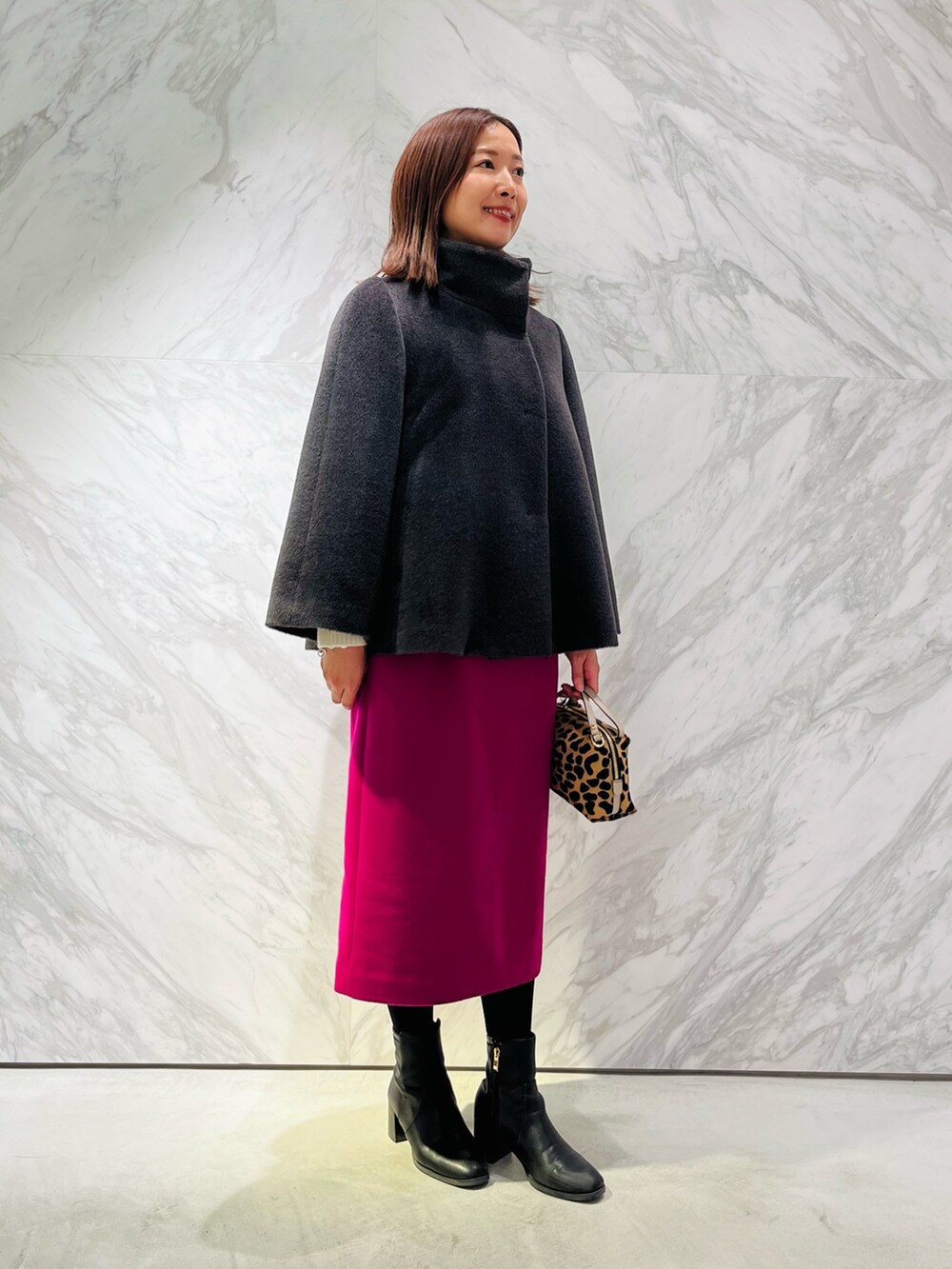 グレー系のその他アウター、ピンク系のスカートを着用したレディースの冬コーディネートの2枚目の写真