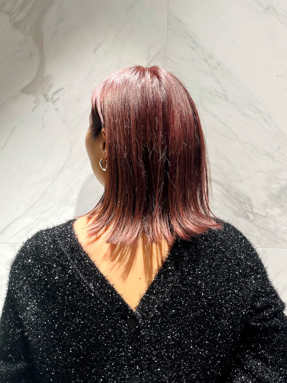 ブルー系のスカート、ブラック系のカーディガン/ボレロ、シルバー系のブローチ/コサージュを着用したレディースの秋コーディネートの5枚目の写真