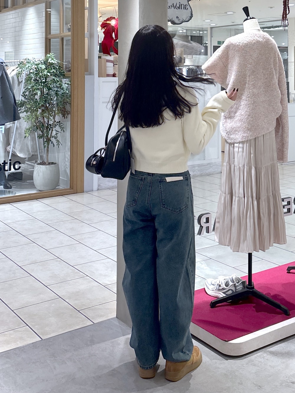 ホワイト系のニット/セーター、ベージュ系のスニーカー、ブラック系のハンドバッグを着用したレディースの冬コーディネートの10枚目の写真