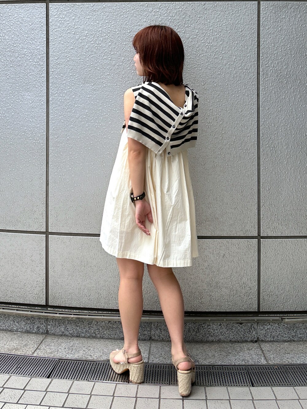 ホワイト系のワンピース、グレー系のカーディガン/ボレロ、グレー系のサンダルを着用したレディースの春コーディネートの4枚目の写真