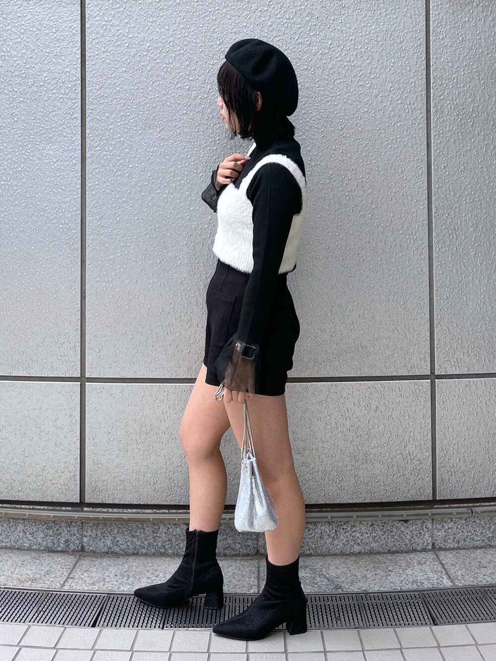 ホワイト系のベスト、ブラック系のその他パンツ、ブラック系のニット/セーターを着用したレディースの秋コーディネートの2枚目の写真