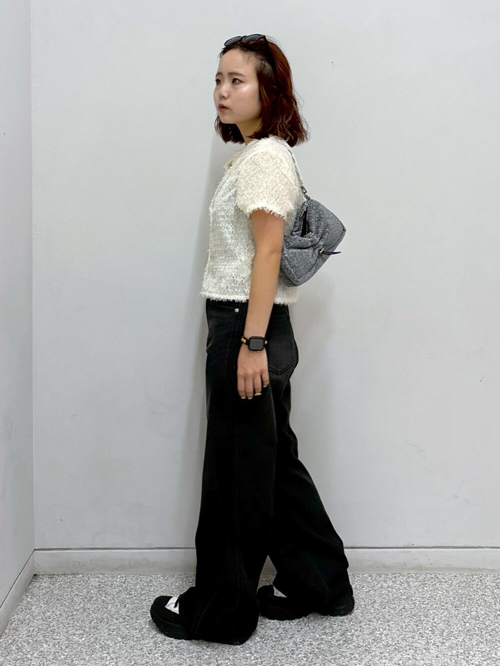 ホワイト系のシャツ/ブラウス、ブラック系のデニムパンツ、シルバー系のハンドバッグを着用したレディースの夏コーディネートの4枚目の写真