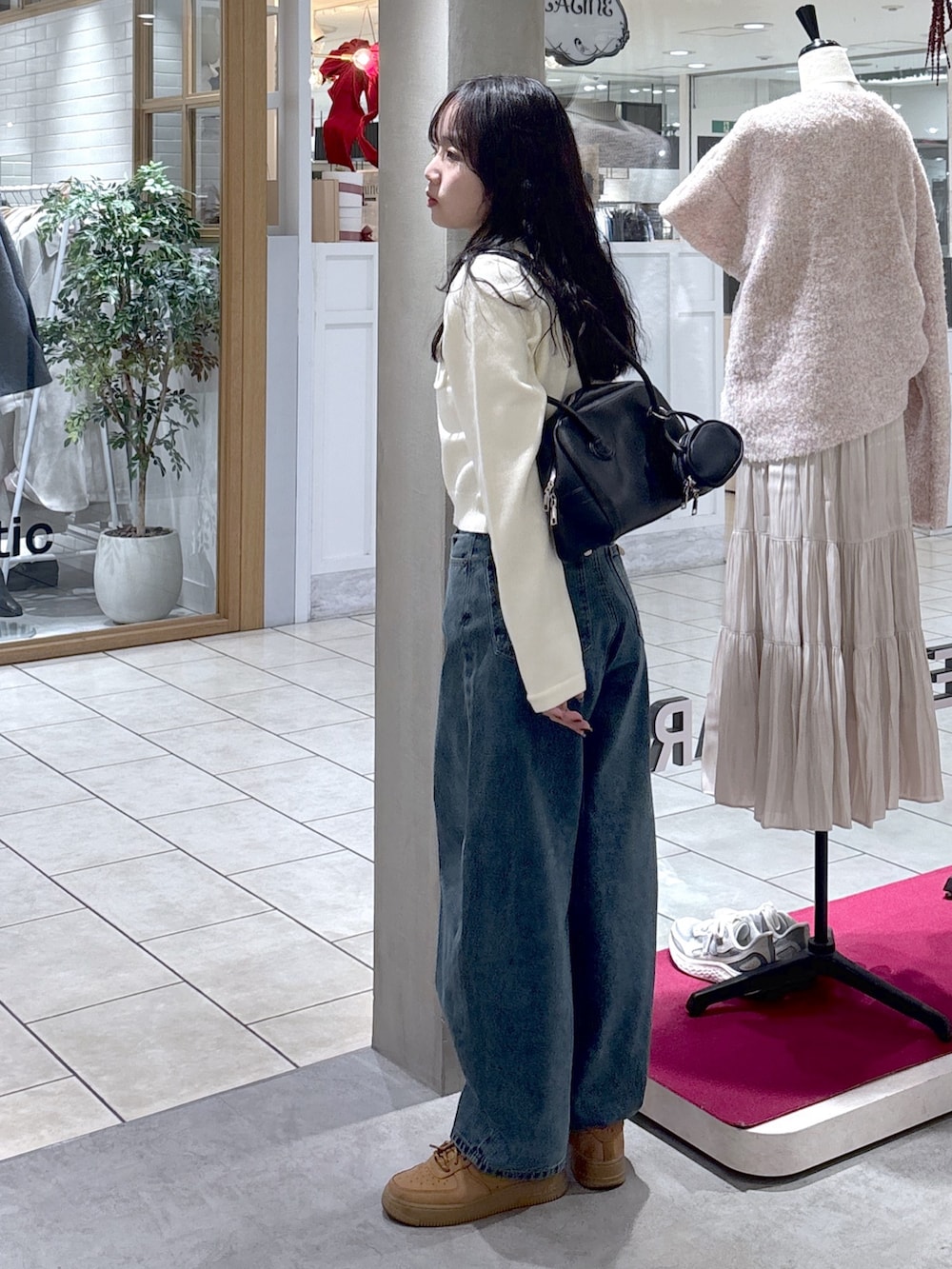 ホワイト系のニット/セーター、ベージュ系のスニーカー、ブラック系のハンドバッグを着用したレディースの冬コーディネートの7枚目の写真