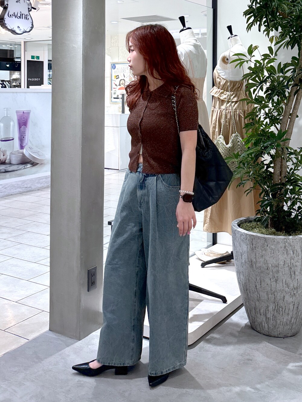 ブルー系のデニムパンツ、ブラック系のパンプス、ブラック系のトートバッグを着用したレディースの夏コーディネートの3枚目の写真