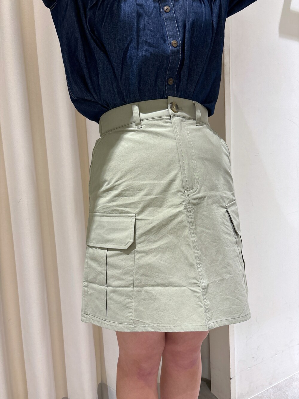 ブルー系のシャツ/ブラウス、グリーン系のスカート、ブラック系のパンプスを着用したレディースの春コーディネートの4枚目の写真