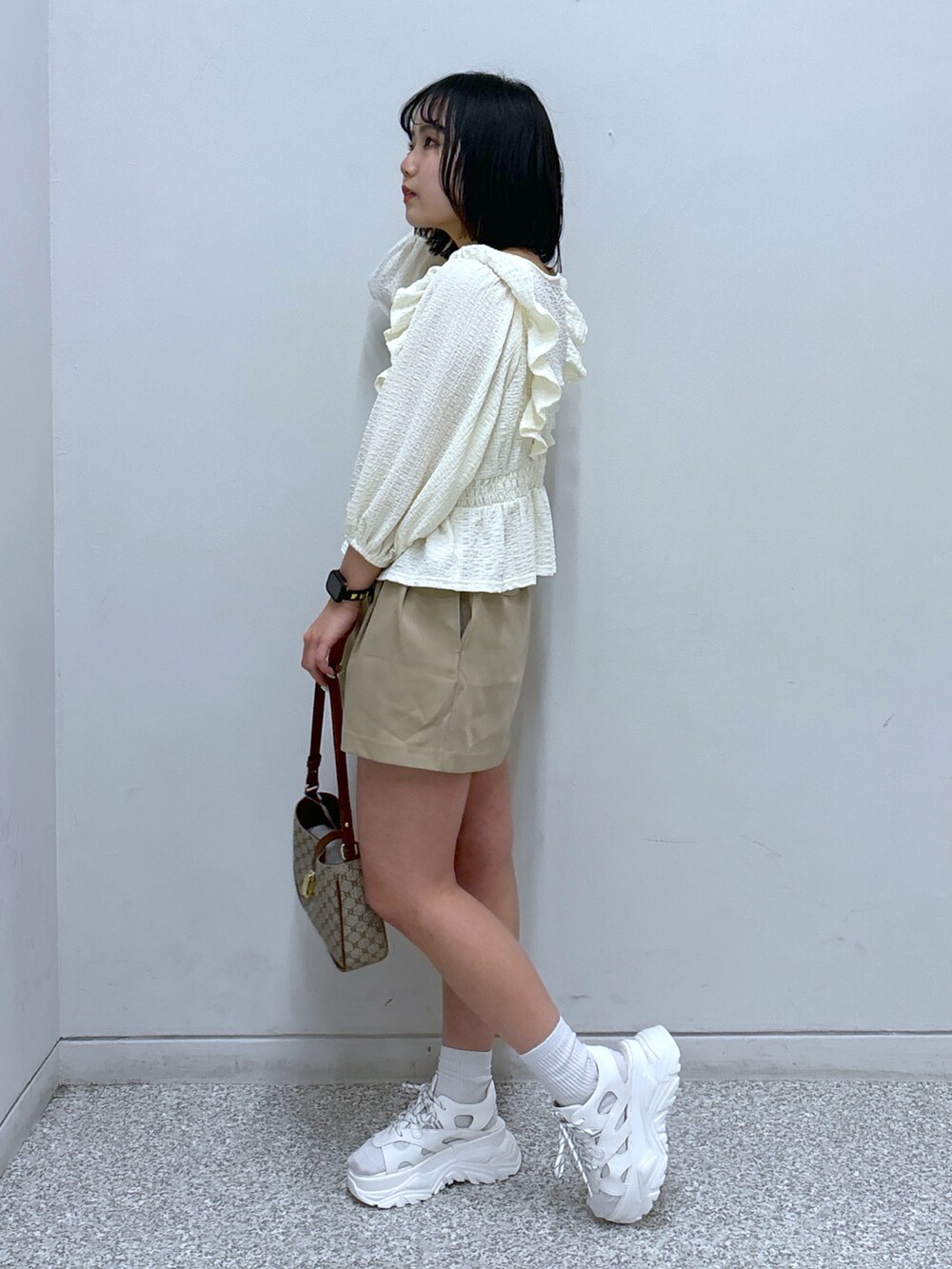 ベージュ系のショルダーバッグ、ホワイト系のサンダル、ベージュ系のその他パンツを着用したレディースの春コーディネートの2枚目の写真