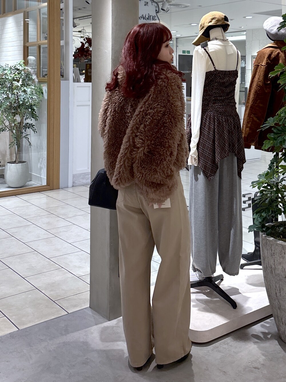 ブラウン系のブルゾン、ベージュ系のデニムパンツ、ブラック系のトートバッグを着用したレディースの秋コーディネートの9枚目の写真