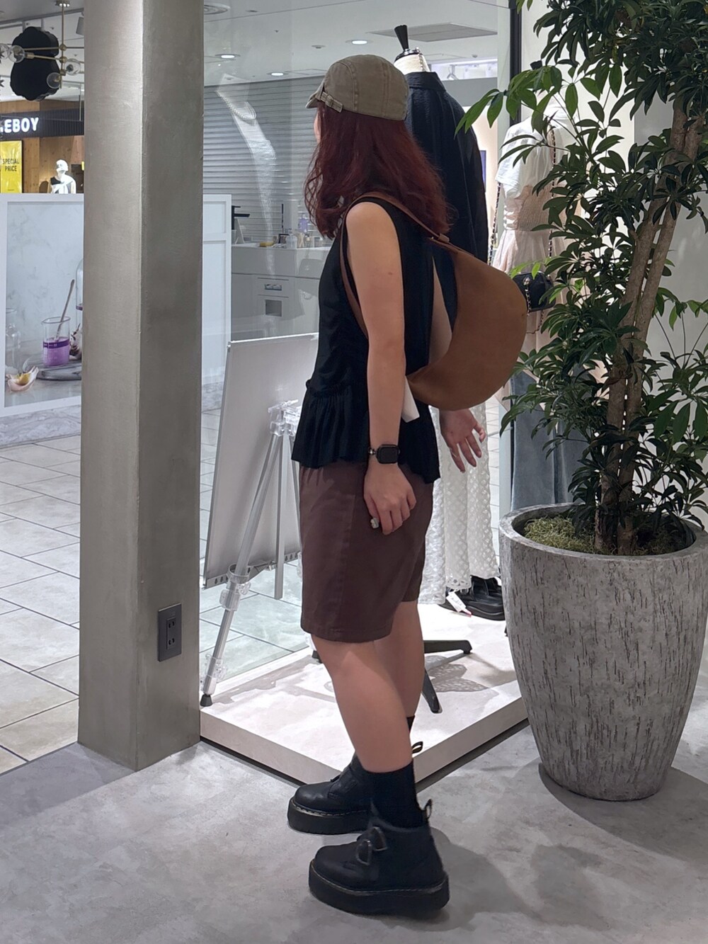 ブラウン系のデニムパンツ、ブラック系のブーツ、ブラック系のTシャツ/カットソーを着用したレディースの夏コーディネートの5枚目の写真