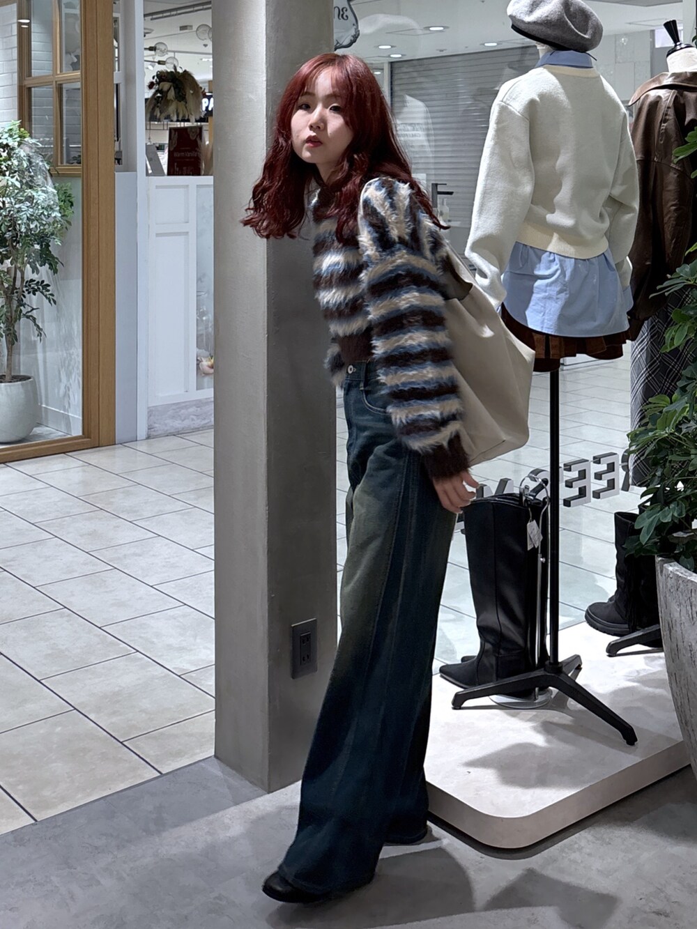 ブラウン系のニット/セーター、ブルー系のデニムパンツ、グレー系のショルダーバッグを着用したレディースの秋コーディネートの6枚目の写真