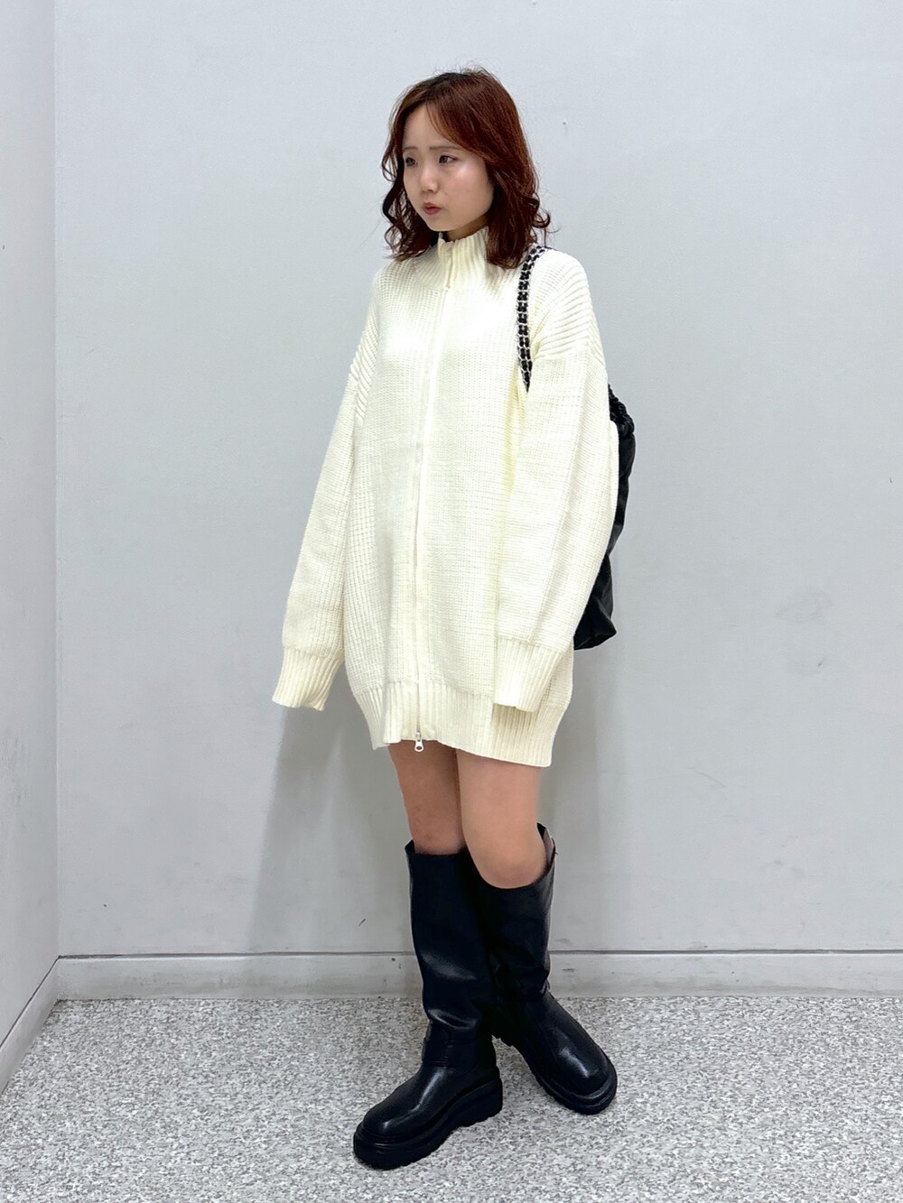 ホワイト系のワンピース、グレー系のスカート、ブラック系のトートバッグを着用したレディースの秋コーディネートの2枚目の写真