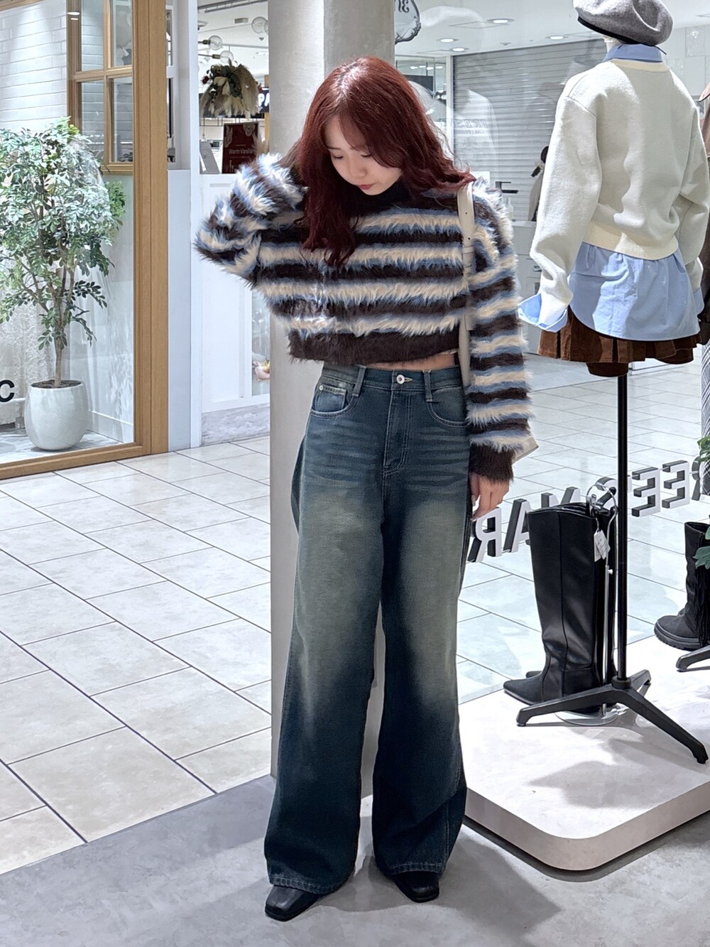 ブラウン系のニット/セーター、ブルー系のデニムパンツ、グレー系のショルダーバッグを着用したレディースの秋コーディネートの3枚目の写真