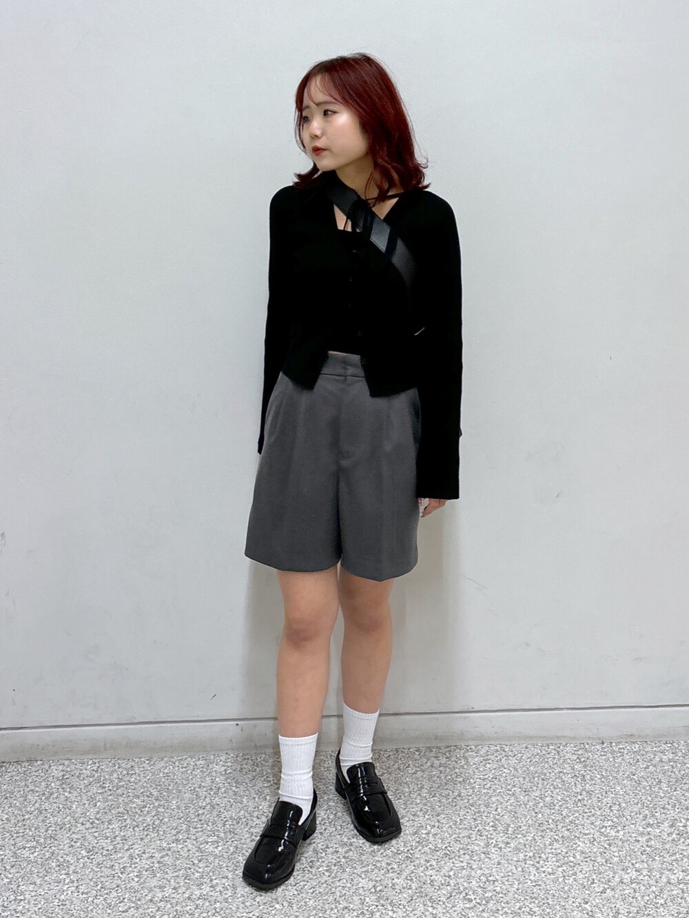 ブラック系のニット/セーター、グレー系のその他パンツ、ブラック系のローファーを着用したレディースの秋コーディネートの2枚目の写真