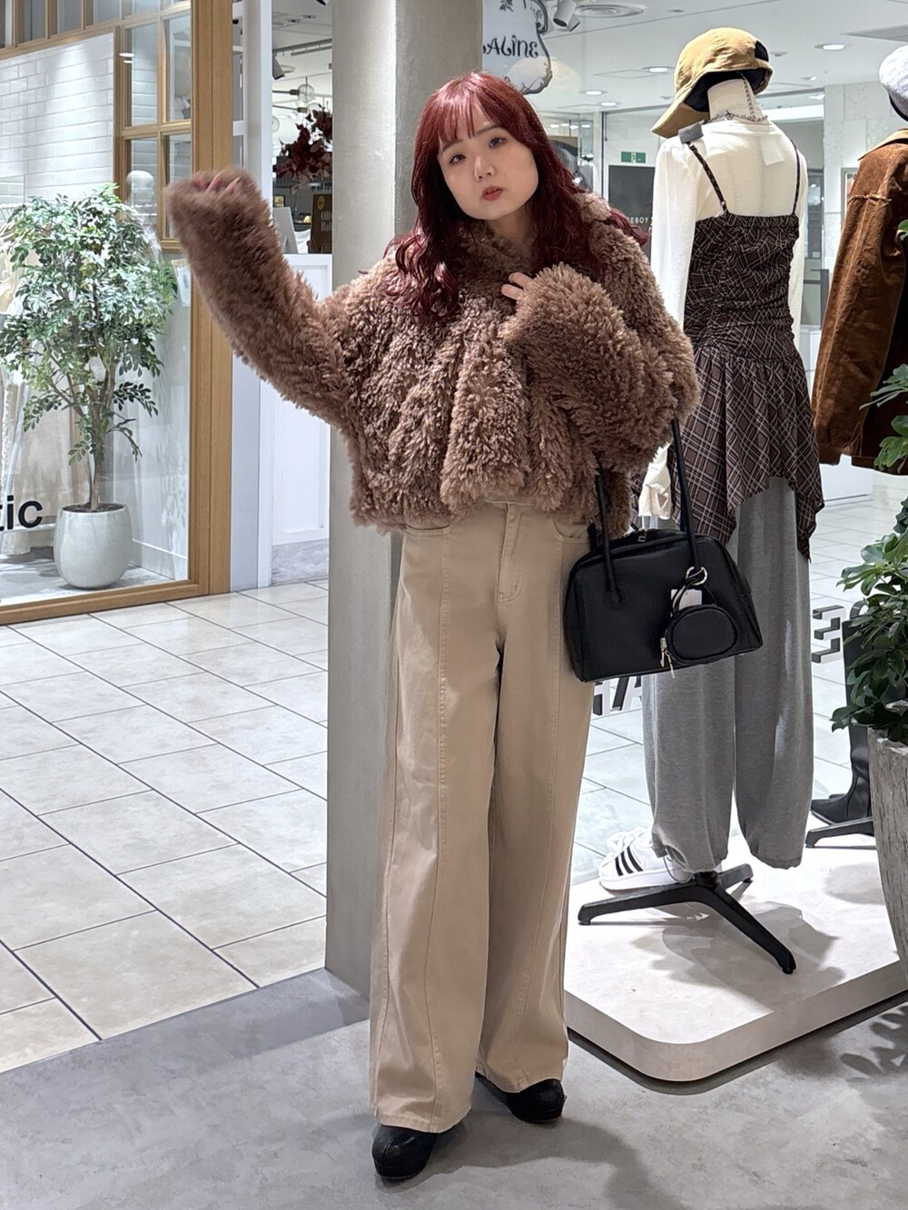 ブラウン系のブルゾン、ベージュ系のデニムパンツ、ブラック系のトートバッグを着用したレディースの秋コーディネートの3枚目の写真