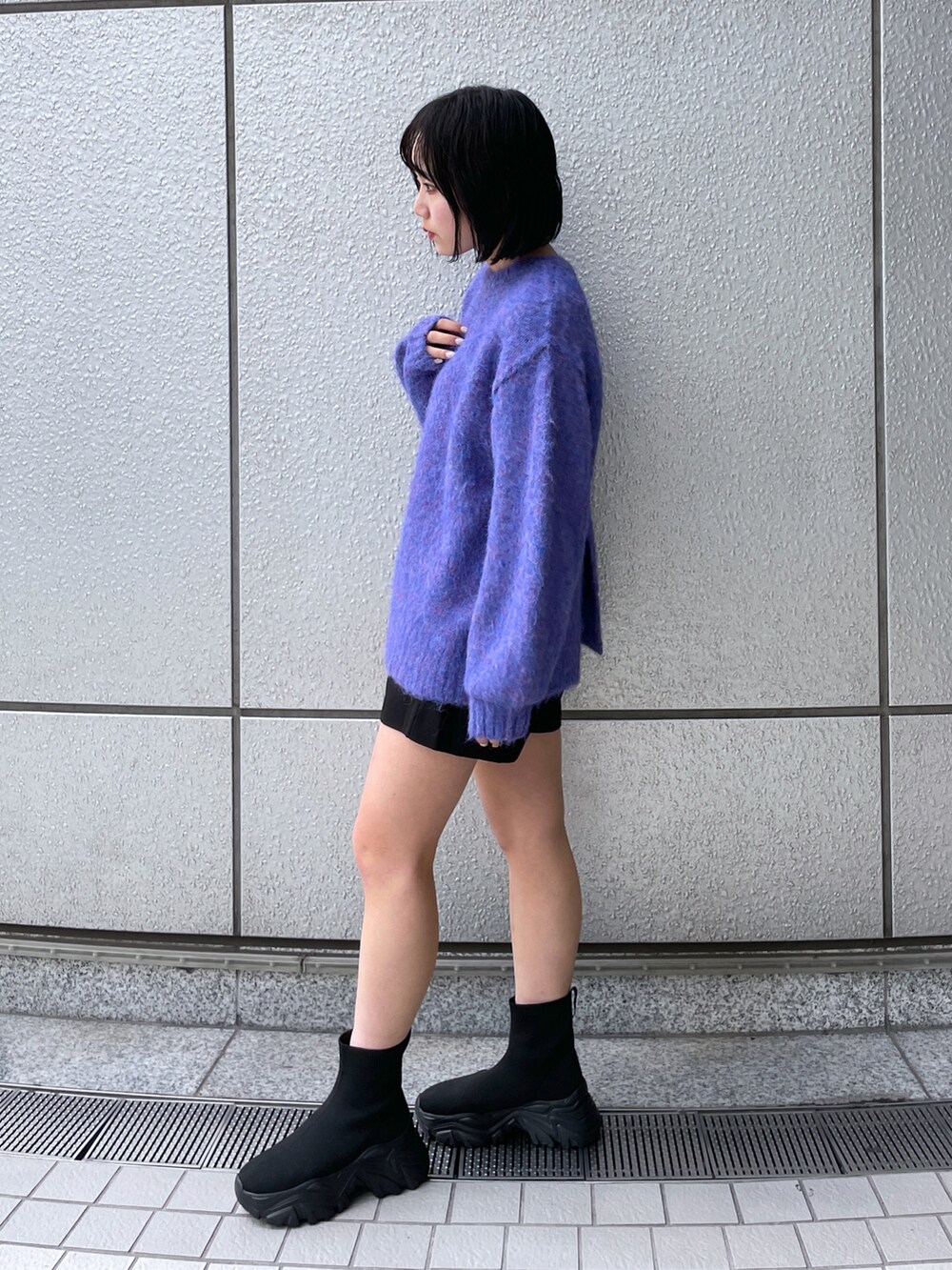 ブルー系のニット/セーター、ブラック系のその他パンツ、ブラック系のブーツを着用したレディースの秋コーディネートの2枚目の写真