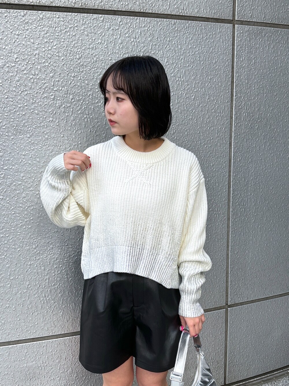 シルバー系のショルダーバッグ、ホワイト系のニット/セーター、ブラック系のその他パンツを着用したレディースの冬コーディネートの4枚目の写真